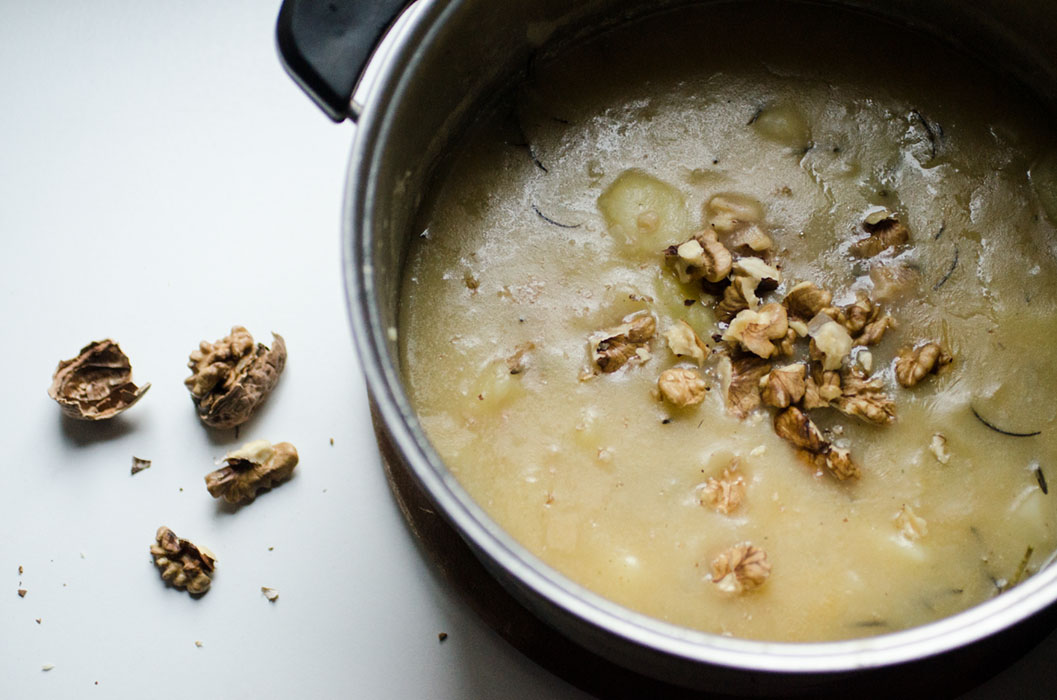 vegan topinambur and potato velvet soup with nuts and fresh thyme